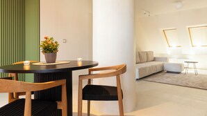 Una sala de estar moderna con una mesa redonda, dos sillas, un sofá y una mesita de centro.