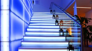 Una escalera con escalones iluminados y faroles colgantes.