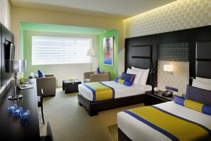 Une chambre d’hôtel avec un grand lit, un bureau avec une lampe, une chaise et une petite table.