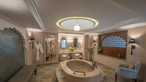 Une salle de bain luxueuse avec une baignoire îlot, un meuble-lavabo doté de plusieurs vasques et un grand miroir.