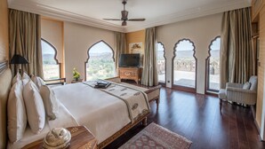 Une chambre spacieuse avec un grand lit, une télévision et une vue sur l’extérieur.