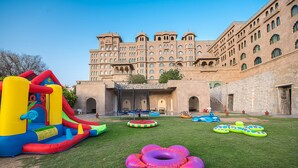 An outdoor inflatable play area with various structures and a large building in the background. - Fairmont Jaipur (Amer)
