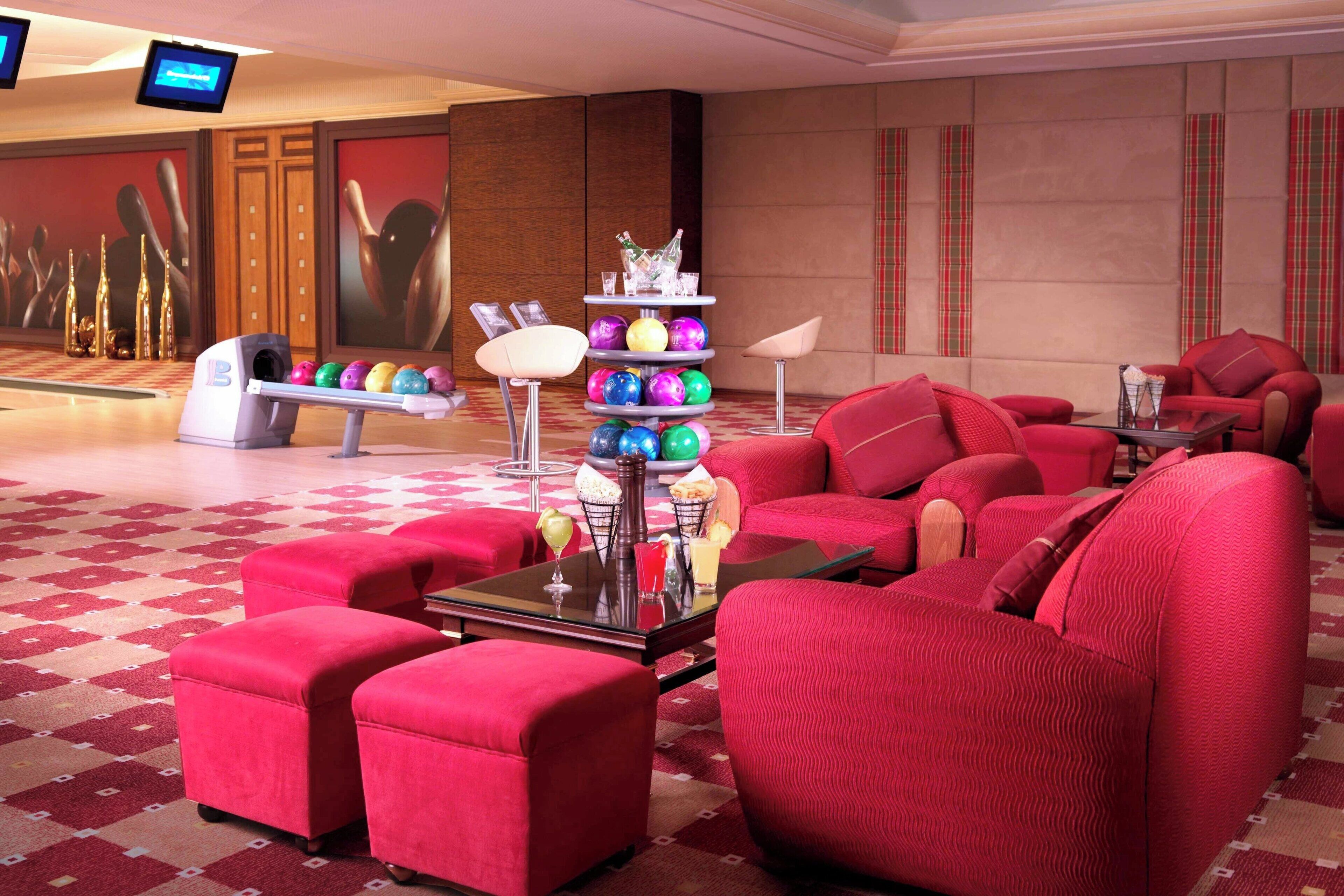 A lobby with red upholstered seating, a glass coffee table, and a colorful ball display.