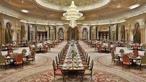 A grand banquet hall with ornate chandeliers, long tables set for dining, and classical architectural details. - The Ritz-Carlton, Riyadh (Riyadh)