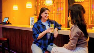 Uma área de bar com decoração em madeira e luminárias pendentes.