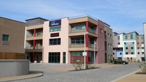 A Travelodge hotel with a modern design, featuring multiple floors and balconies. - Travelodge Caernarfon (Caernarfon)