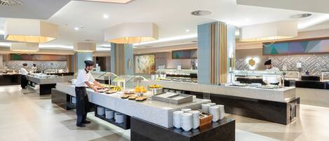 Uma moderna disposição de buffet com diversas estações de serviço, uma ilha central com alimentos e um design limpo e contemporâneo.