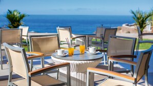 A round table with chairs and a view of the ocean. - Hotel Riu Buenavista - All Inclusive (Adeje)