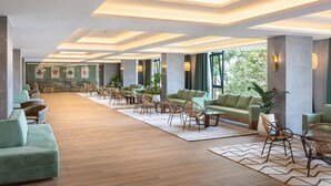 A spacious lobby with a modern design, featuring a long reception area, multiple seating arrangements, and large windows allowing natural light. - Hotel Riu Buenavista - All Inclusive (Adeje)