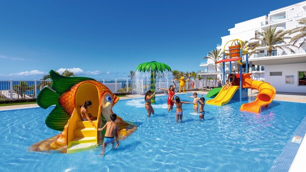 A swimming pool with slides and a fish-shaped water feature. - Hotel Riu Buenavista - All Inclusive (Adeje)