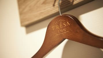 Un perchero de madera con el texto "SOTETSU FRESA INN" grabado.