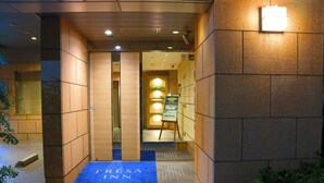 A hotel entrance with a blue mat labeled "FRESA INN" leading to a reception area. - Sotetsu Fresa Inn Tokyo Kyobashi (Tokyo)