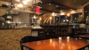 A restaurant interior with a bar area, seating, and a kitchen in the background. - Sotetsu Fresa Inn Tokyo Kyobashi (Tokyo)