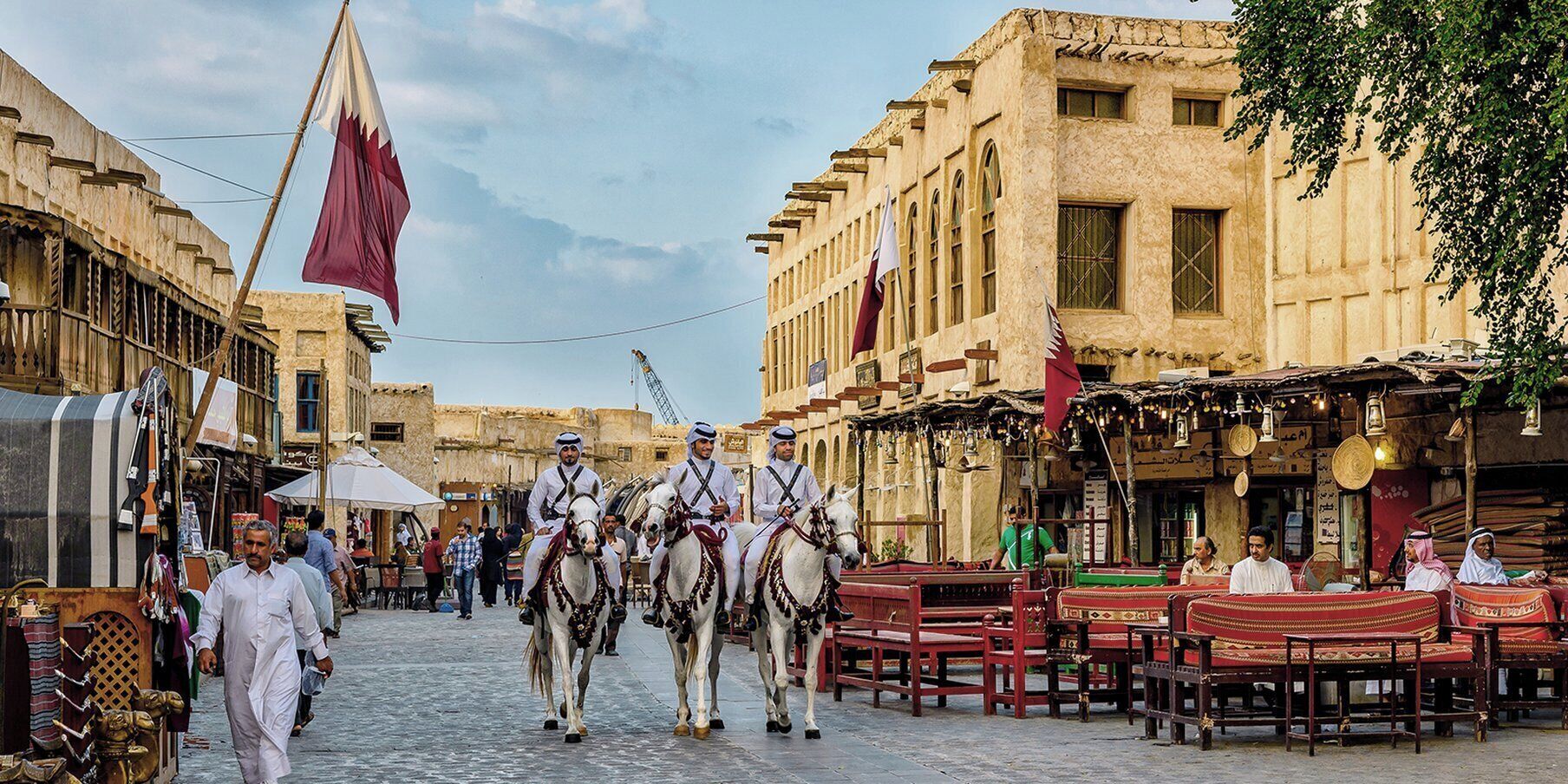 A street scene with traditional architecture, a flag, and people.