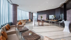 Eine geräumige Lobby mit Sofas, Tischen und einer Rezeption.