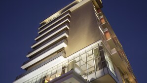 Un edificio moderno con varios pisos, ventanas grandes y techo plano.