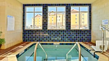 Una piscina techada, sillones reclinables de piscina