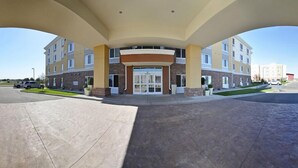 A multi-story hotel with a central entrance, large pillars, and a parking lot. - Holiday Inn Express and Suites Williston by IHG (Williston)