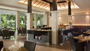Un área de comedor moderna con servicio de buffet, asientos cómodos y vistas al exterior.