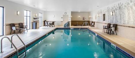 Piscina interior com borda azulejada, indicador de profundidade de 1,5 metros e placa de aviso indicando que mergulhos não são permitidos.