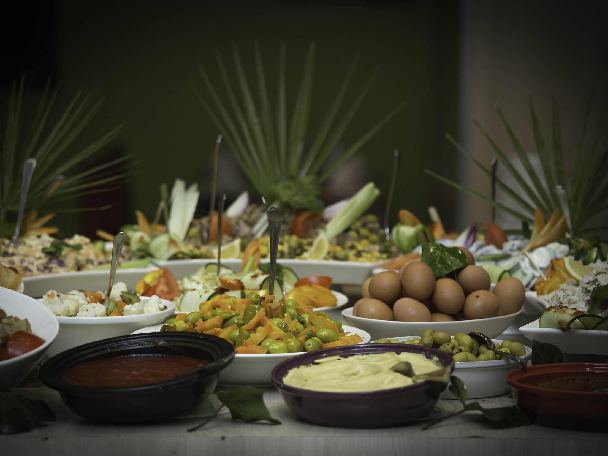 Une table sur laquelle sont disposés divers aliments et des bols, probablement pour un buffet.