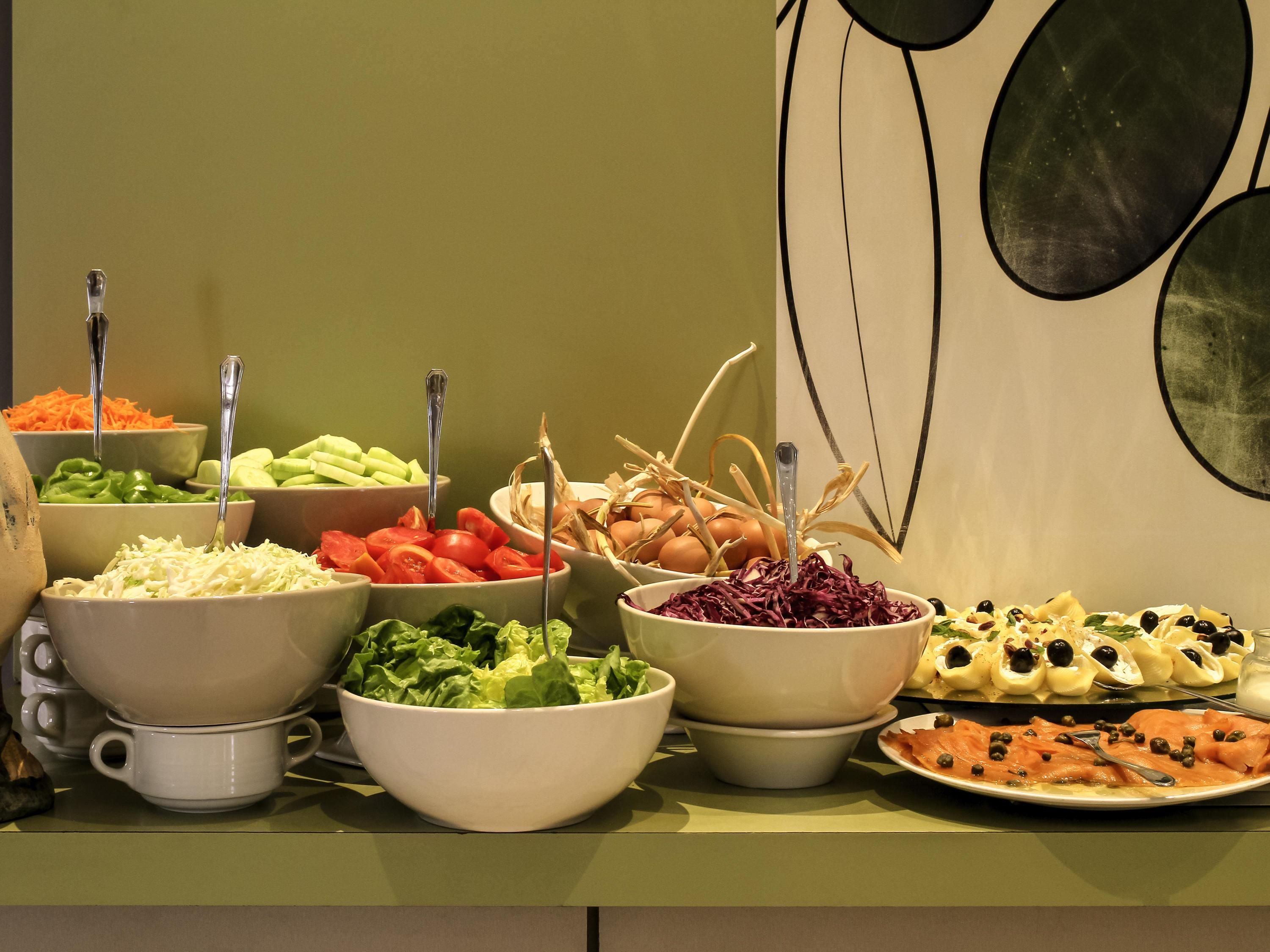 Una mesa de buffet con diversos alimentos y utensilios.