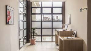 A modern reception area with a glass door, a reception desk, and a potted plant. - ibis Constantine (Constantine)