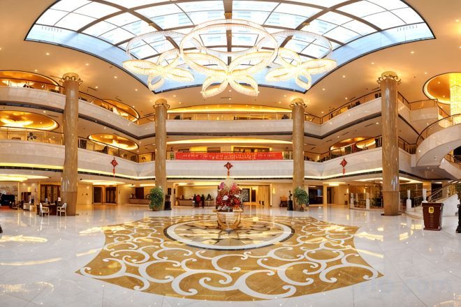 A multi-level atrium with a central decorative fountain, multiple balconies, and a large glass ceiling.