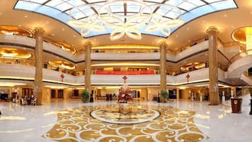 A multi-level atrium with a central decorative fountain, multiple balconies, and a large glass ceiling.