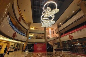 Indretning i et stort, fleretage shoppingcenter med en iøjnefaldende dekorativ lampe.