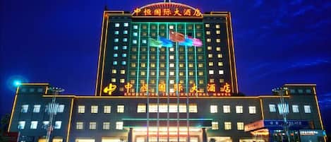 Un gran edificio de hotel con varios pisos y una entrada destacada.
