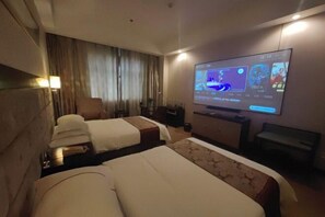 Ein Hotelzimmer mit zwei Betten, einem Fernseher, einem Schreibtisch und einem Sessel.