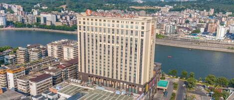 Um hotel moderno com vista para um rio e o horizonte urbano.