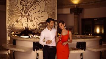 A bar area with a large decorative wall, a curved counter, and a tiled floor.