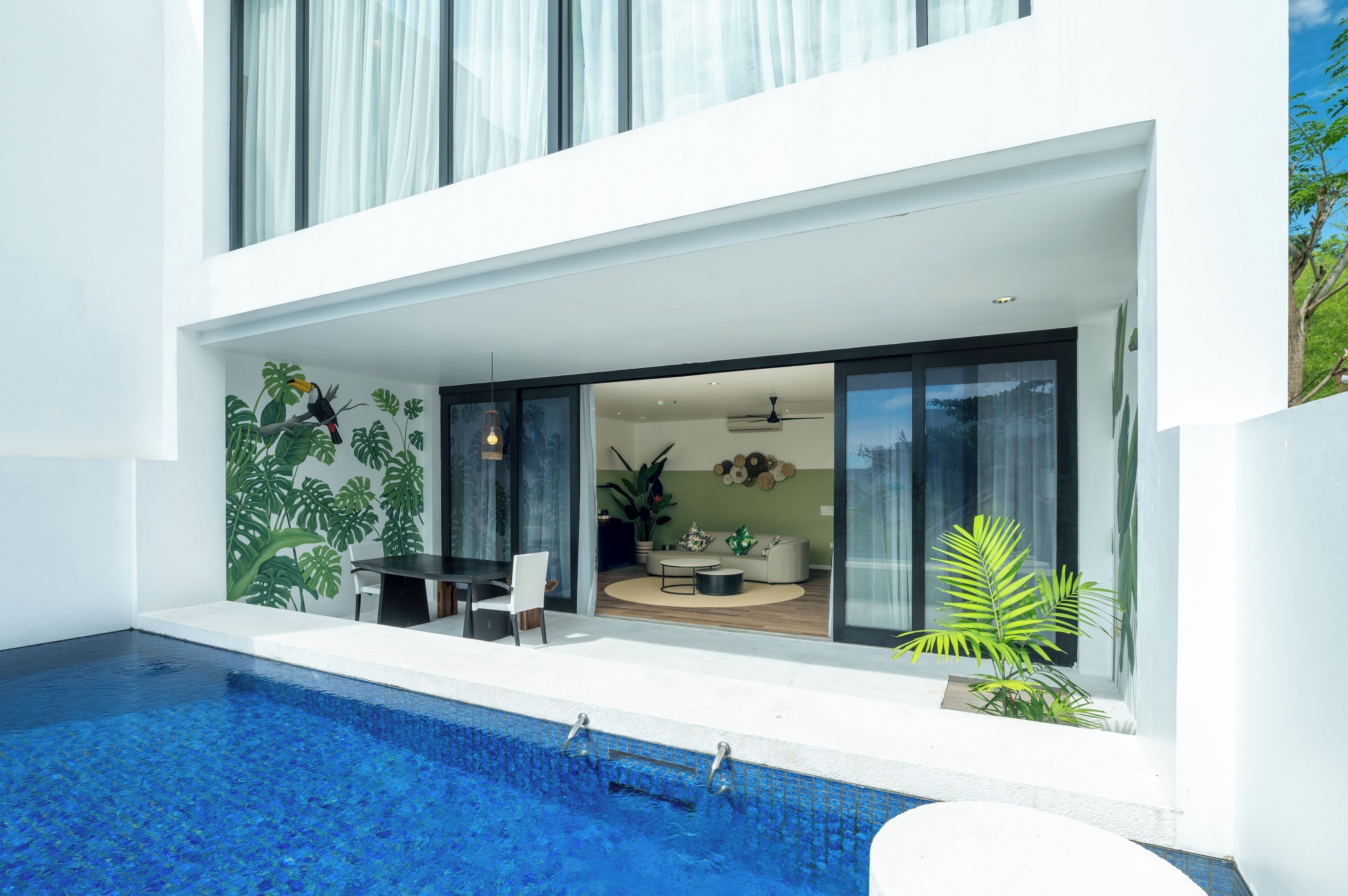 Una casa moderna con piscina, comedor y sala de estar con sofá y mesa de centro.