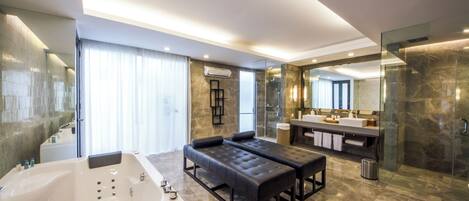 A modern bathroom with a large bathtub, a bench, a glass shower enclosure, and a vanity with a mirror.
