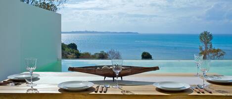 A dining table set for two with a view of the ocean.