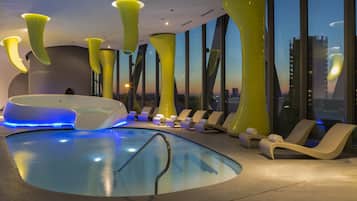 Una piscina techada, sillones reclinables de piscina