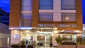 Un bâtiment d’hôtel avec une enseigne indiquant « NH HOTELS » et « NH ROYAL URBAN 93 ».