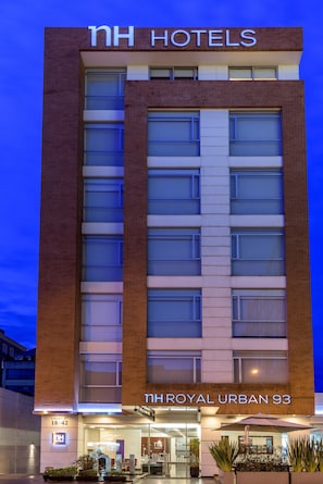A hotel building with a sign reading "NH HOTELS" and "NH ROYAL URBAN 93". - NH Bogotá Urban 93 Royal (Bogotá)