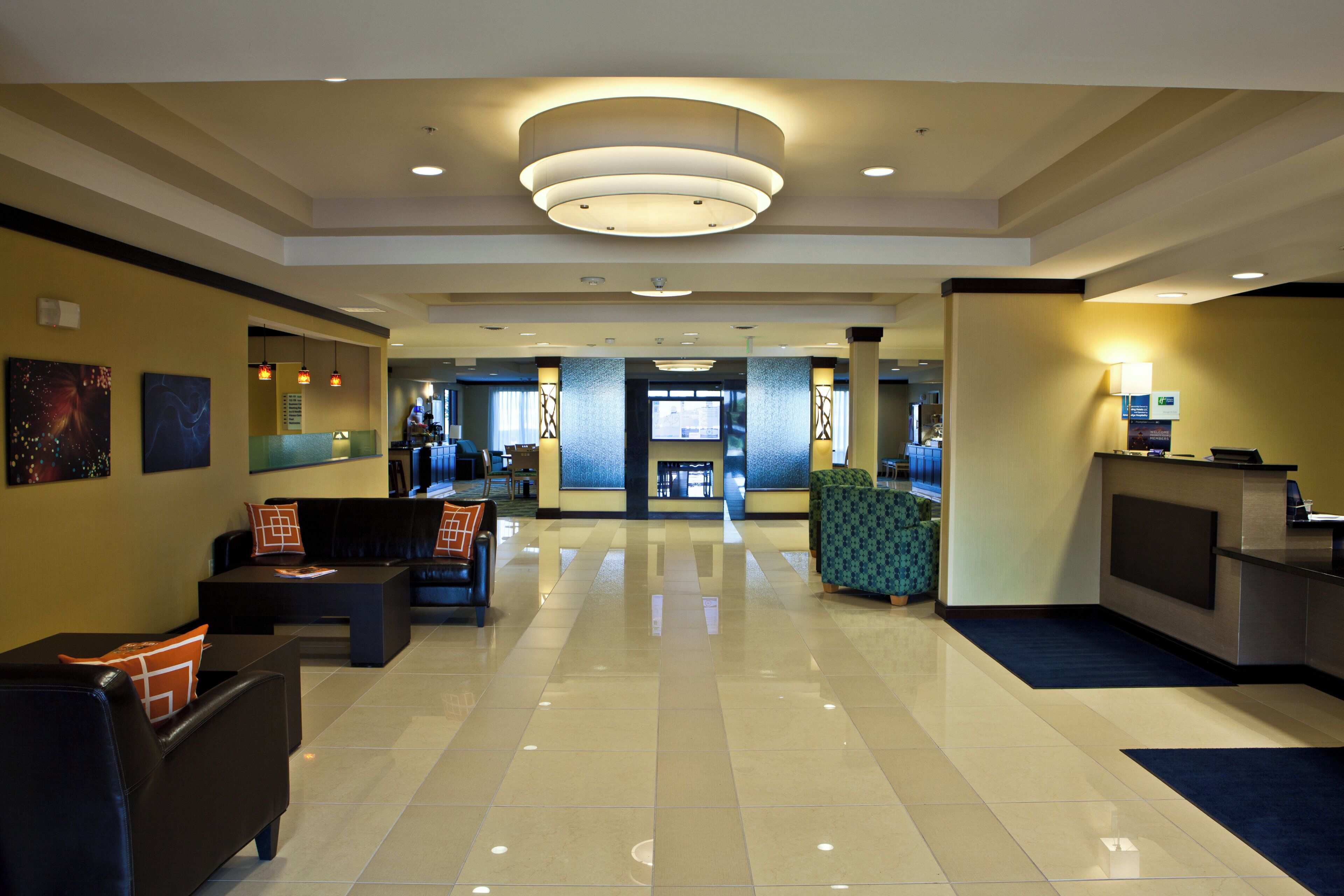 A hotel lobby with a reception desk, seating area, and a view of the lobby in the background.