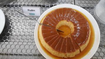 A dessert named Pudim on a metal table with a grid pattern.