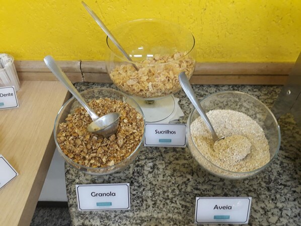 Una presentación de granola, edulcorantes y avena en tazones etiquetados sobre una encimera.