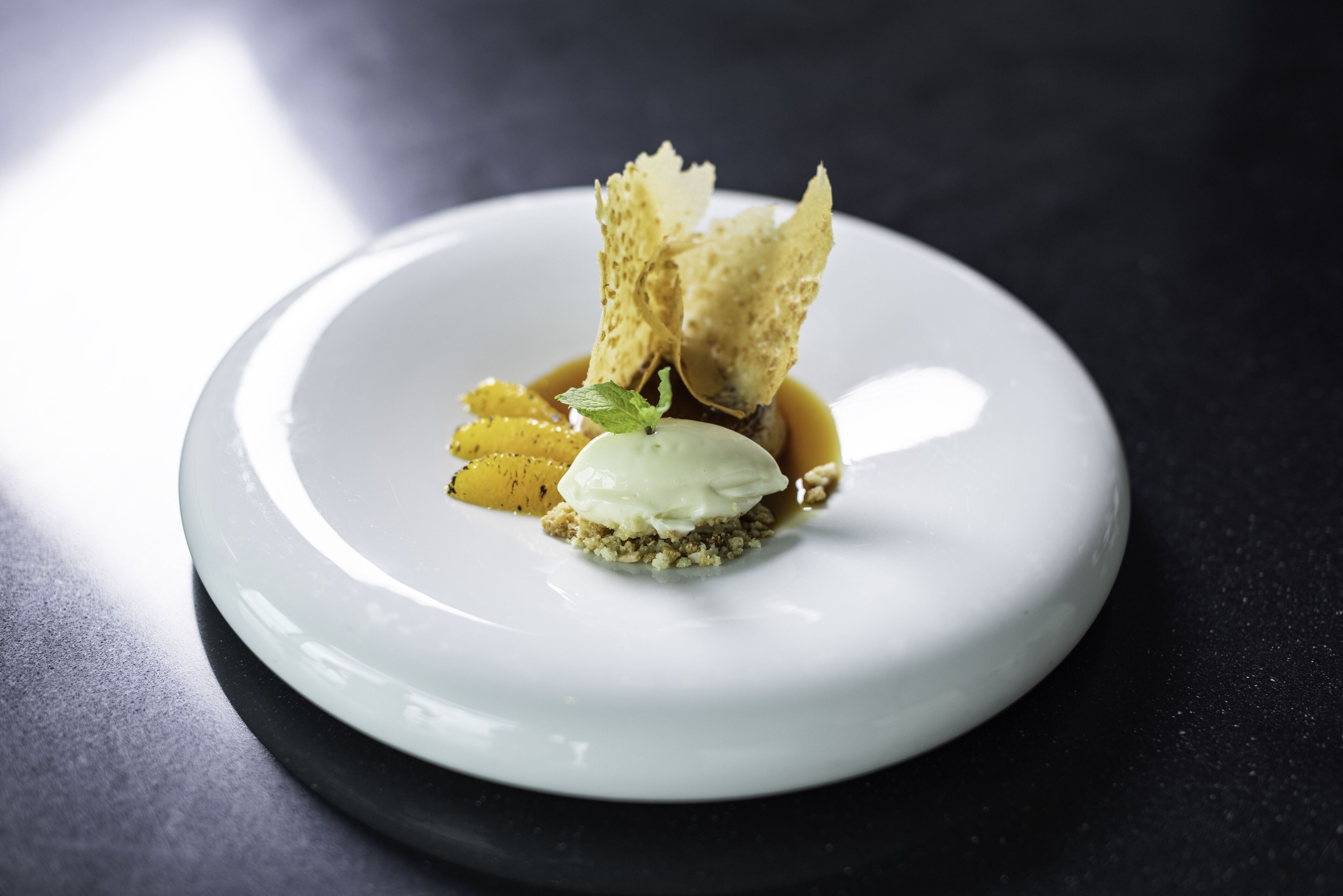 A dessert on a white plate with a dark background.