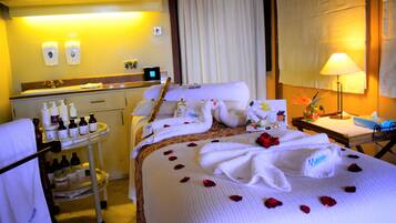 Relax in a serene space with a neatly made bed, vanity area, and elegant design.