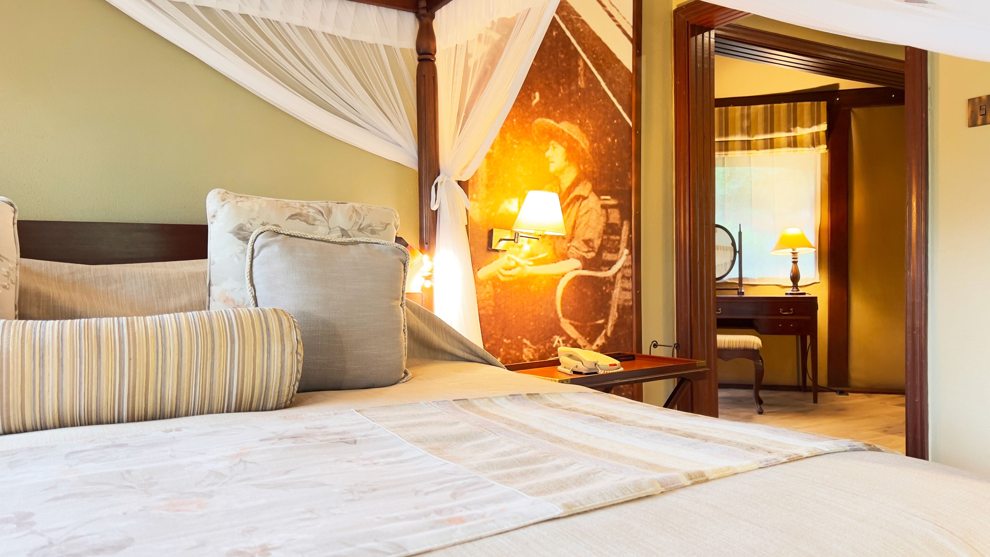 A hotel room with a bed, a desk, a chair, and a nightstand.
