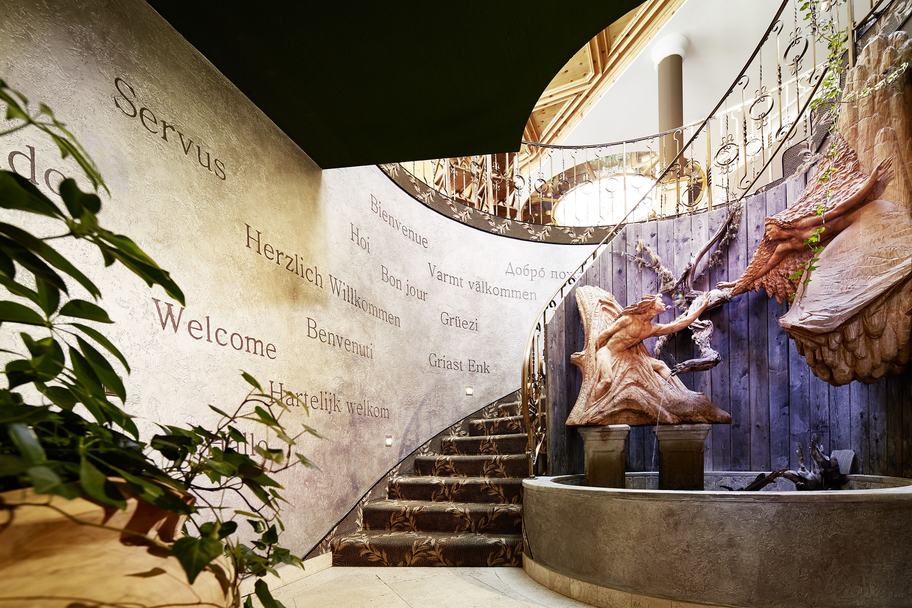 Un magnifique escalier, avec un mur de marbre orné de messages d’accueil dans différentes langues.