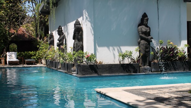 A swimming pool with statues and potted plants. - Alam Bali Hotel (Nusa Dua)
