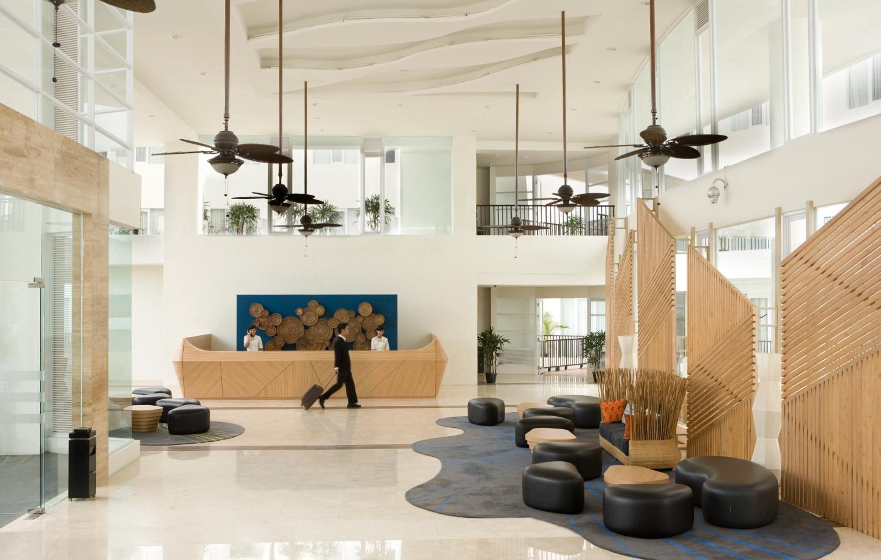 A spacious lobby with high ceilings, multiple seating areas, and a central reception desk.