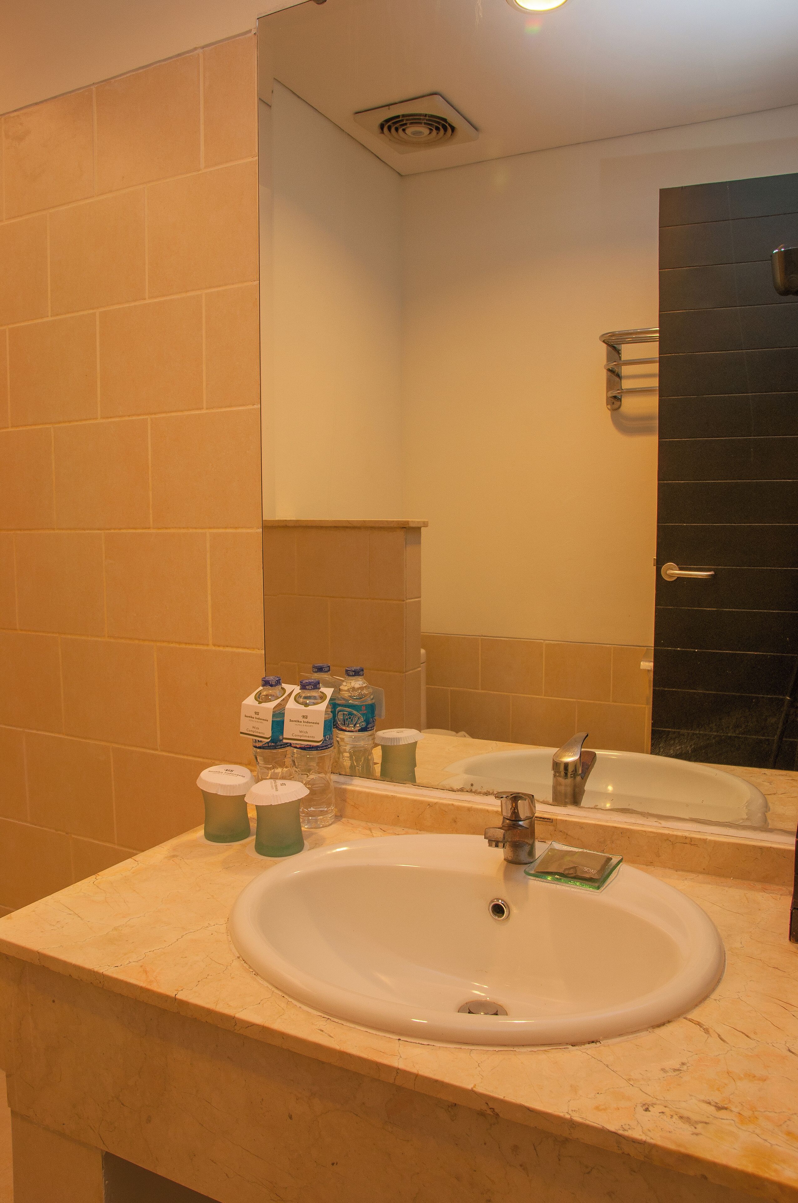 Une salle de bain équipée d’un lavabo, d’un miroir et d’articles de toilette.